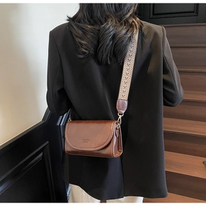 Detail of vintage brown square crossbody bag with ethnic patterned wide woven strap