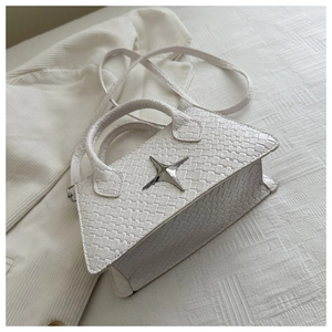 Detail of white woven texture handbag with silver star ornament and sleek shoulder strap