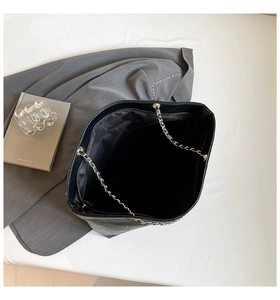 Top view of spacious black tote bag interior with zipper pocket and chain strap detail