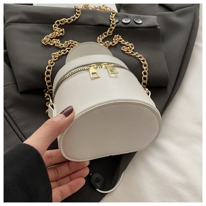 Detailansicht der cremeweißen Mini-Beuteltasche mit Doppel-Reißverschluss und Goldkette
