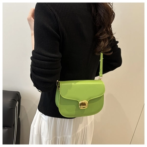Détail du sac besace vert montrant le grain du cuir et la boucle dorée élégante
