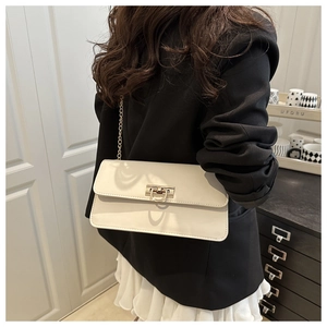 Detailed view of cream PU leather shoulder bag with golden horseshoe buckle and chain strap