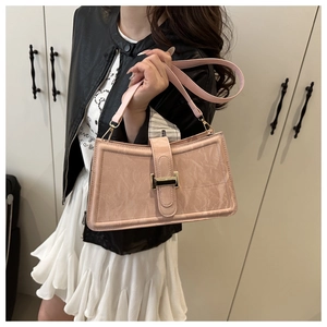 Close-up of pink baguette bag with marble texture and gold buckle held by a model