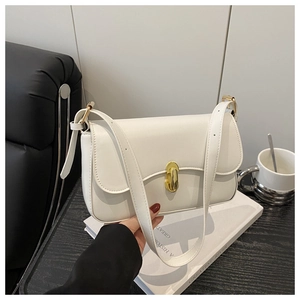 Detail of white leather shoulder bag featuring elegant gold oval buckle and adjustable strap