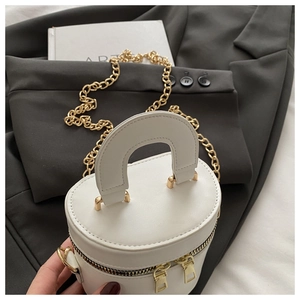 Details der weißen Mini-Zylindertasche mit goldener Kette und Doppel-Metallreißverschluss