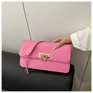 Dettaglio borsa con patta rosa acceso con chiusura dorata e tracolla a catena