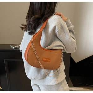 Detail of caramel hobo bag featuring woven texture, gold chain and Miss mini logo