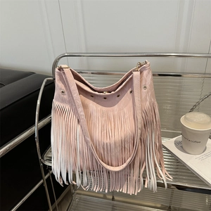 Borsa a secchiello rosa stile boho con frange e fibbie metalliche su supporto argentato