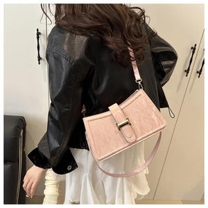 Detail of light pink shoulder bag with marble texture leather and golden buckle clasp