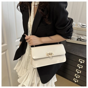 Detail of off-white minimalist crossbody bag with gold D-ring buckle and chain strap