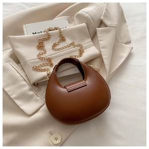 Close-up of brown crescent hobo bag with textured finish and golden chain strap