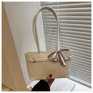 Détail du sac cabas en cuir verni crème avec lanières et nœud à carreaux