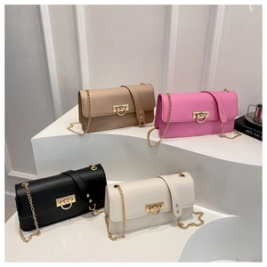 Detail of four colorful baguette bags on white steps with gold D-buckles and chain straps