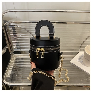 Details der schwarzen Zylindertasche mit weißen Nähten, Doppelreißverschluss und Kette