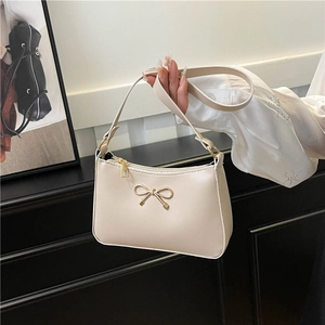 Elegant cream PU leather shoulder bag featuring a decorative gold bow and zipper closure