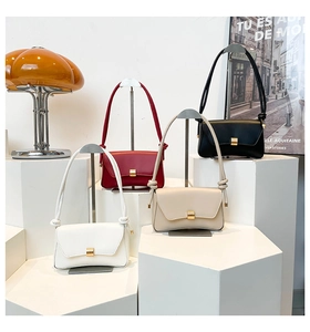 Minimalist leather baguette bags in four colors arranged on geometric display stands