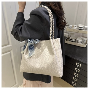 Detail of cream woven tote bag with blue printed silk scarf and thick braided handles
