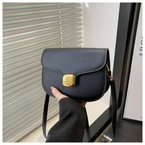 Close-up of black saddle bag with smooth PU finish and gold-tone square push lock