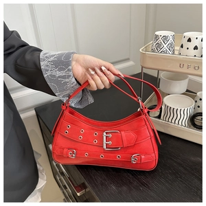 Detail of red vintage shoulder bag with silver buckle and eyelet metallic accents