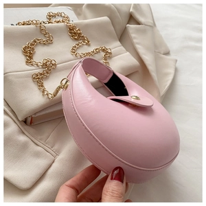 Detailed macro view of pink crescent bag showing fine stitching and gold chain