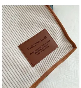 Close-up of corduroy fabric texture and leather label on the large shoulder tote bag