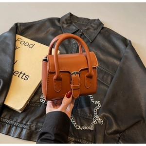 Gros plan sur un mini sac à main marron caramel avec boucle et bandoulière chaîne