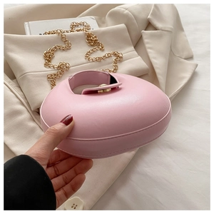 Detailed close-up of pink crescent crescent bag with gold chain and circular lock