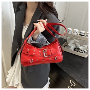 Detail view of red punk leather shoulder bag with metallic buckles and eyelet straps