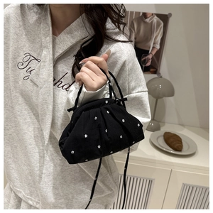 Detail of floral drawstring pouch bag held by hand in a minimalist lifestyle setting