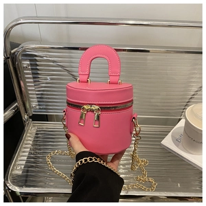 Detailansicht der pinken Leder-Minibeuteltasche mit Gold-Reißverschlüssen und Kette