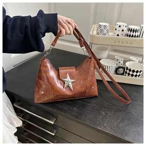 Detail of a brown PU leather shoulder bag with silver star rivets and metallic star buckle