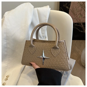 Detail of khaki croc-embossed leather handbag with silver star metallic emblem