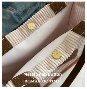 Close-up of magnetic buckle and corduroy texture on white large capacity tote bag