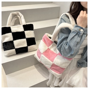 Detail view of plush checkerboard tote bag showing soft lamb wool texture and handles