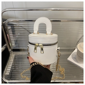 Detailansicht der weißen zylindrischen Handtasche mit goldenen Doppelreißverschlüssen
