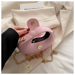 Macro view of the pink mini bag interior featuring a golden magnetic closure and chain