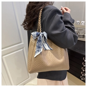 Detail of woven large tote bag with decorative silk scarf and textured finish