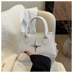 Close-up of a white woven texture handbag featuring a silver star metal ornament
