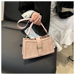 Close-up of pink baguette bag with marble texture and golden metal clasp detail