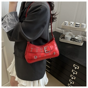 Detail of red leather Y2K shoulder bag with silver metallic buckles and eyelets