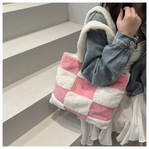 Detail of plush pink and white checkerboard tote bag worn with a white dress