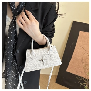 Close-up of white crocodile pattern square handbag with silver star metal hardware detail