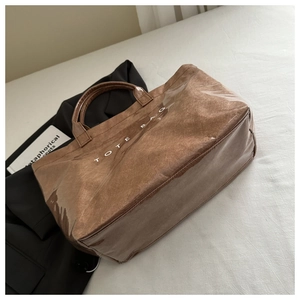 Close-up of brown textured tote bag with high-gloss finish and white Tote Bag lettering