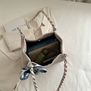 Minimalist cream woven tote bag with braided handles and decorative blue scarf