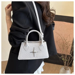 Detail of white square bag with woven texture, silver star buckle and adjustable strap
