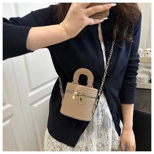 Detailansicht der hellbraunen Mini-Beuteltasche mit Goldkette und Doppelreißverschluss