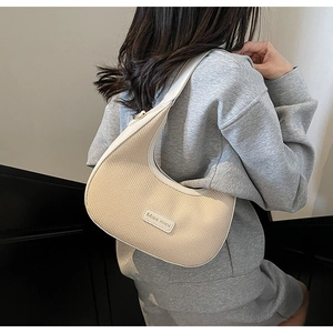 Detail of beige woven hobo bag with white leather trim and Miss mini logo plate