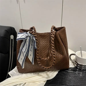 Brown woven tote bag with silk scarf decoration and thick braided handles for daily use
