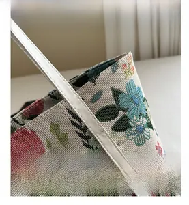 Close-up of floral jacquard tote bag featuring premium stitching on white leather straps
