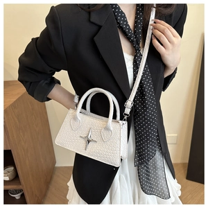 Detail of a chic cream mini handbag with a silver star buckle and woven leather texture